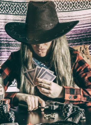 Old west cowgirl gunslinger sitting at table playing poker