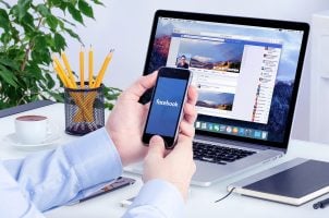 Facebook, Social Media, Mann mit Handy, Laptop