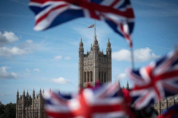 British flags fly in front of the Palace of Westminster